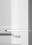 A modern, sleek linear glass pendant light with stainless steel accents, suspended over a counter, dispersing a warm glow.