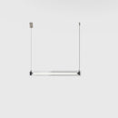 A modern, sleek linear glass pendant light with stainless steel accents, suspended over a counter, dispersing a warm glow.