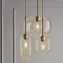 Brass and glass sculpted pendant lights with gold fittings clear and cognac glass shades three sizes hanging at varied lengths