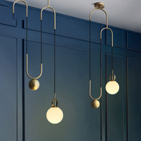 In Balance Mid-Century Pendant Light black gold brass orb with glass shade adjustable cord