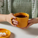 round textured stripe orange ceramic cup with matching saucer