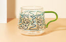 rounded clear glass van gogh-design mug with orange green handle